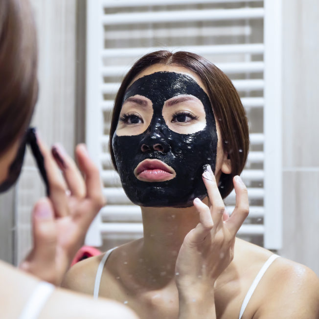 woman putting on clay mask