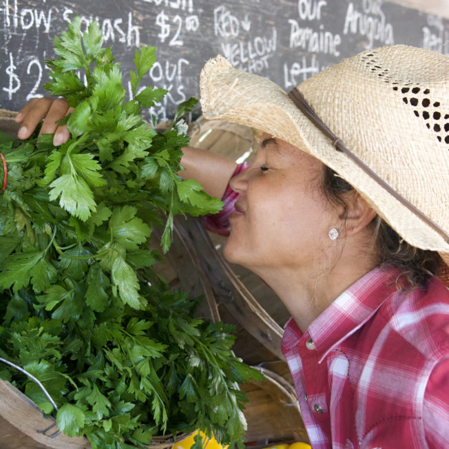 woman smiling smelling produce